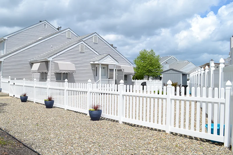 White picket PVC fencing separating two property backyards